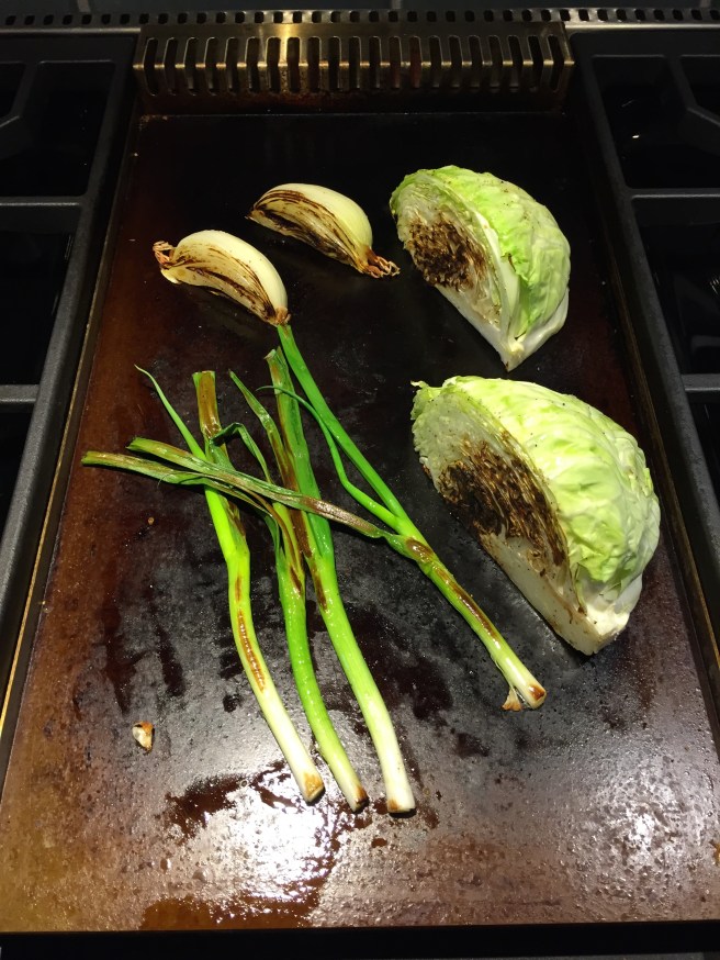 Flip them over to char other side.  Scallions are already done. Cabbage and onion will need some more time.  They should be tender, but still have some crunch. 