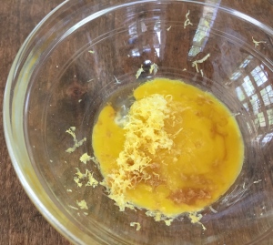 Whisk the egg yolk, lemon juice, zest, vanilla, and water together.
