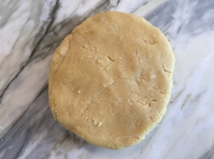 With lightly floured hands, knead the dough 4 or 5 times until it comes together.  Form into a 5 inch disk.