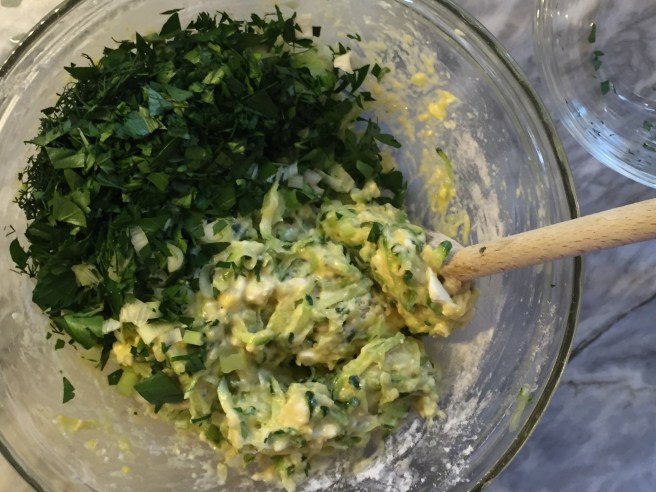 adding the herbs to the zucchini mixture