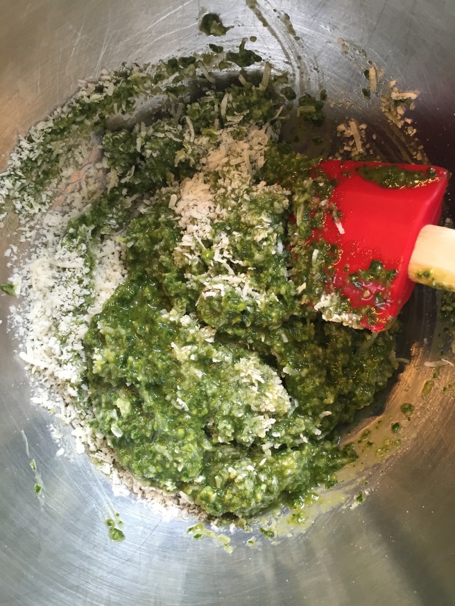 Mixing the parmesan and romano cheeses into the pesto by hand.