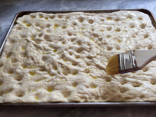 Brushing the dough with olive oil