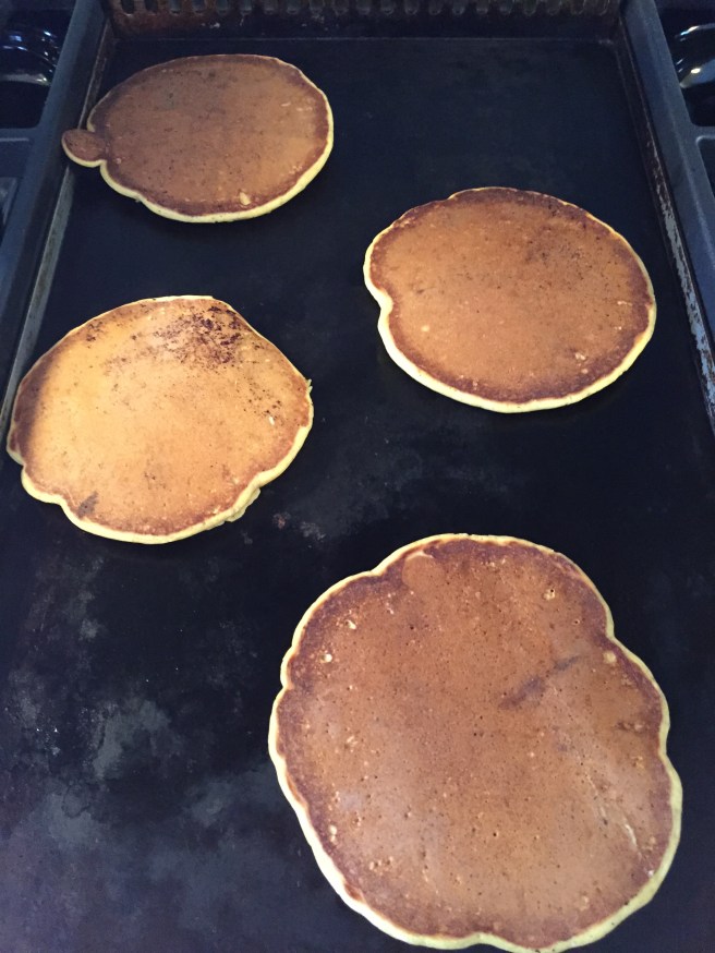 Flipped pancakes on the griddle.