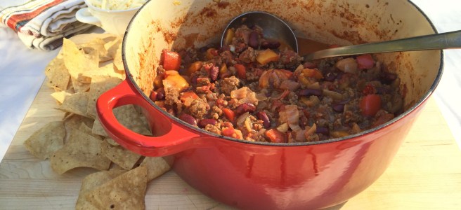 Chili con carne with tortilla chips, cheese, and sour cream.
