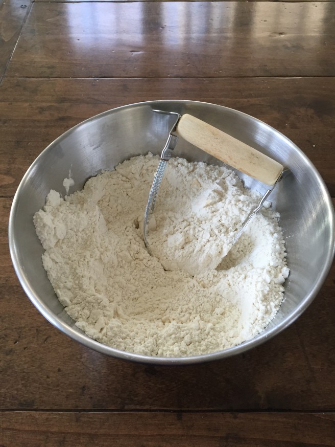 Using a pastry blender to cut butter into flour.
