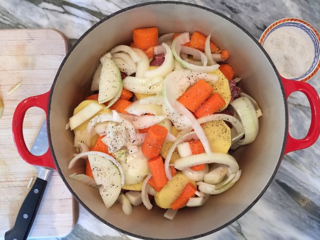 another layer of lamb, followed by potatoes, carrots, and onions seasoned with salt and pepper.